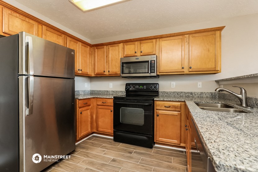 the kitchen has granite counter tops and wood cabinets and stainless steel appliances