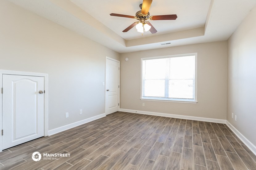 the spacious living room with vinyl flooring and a ceiling fan