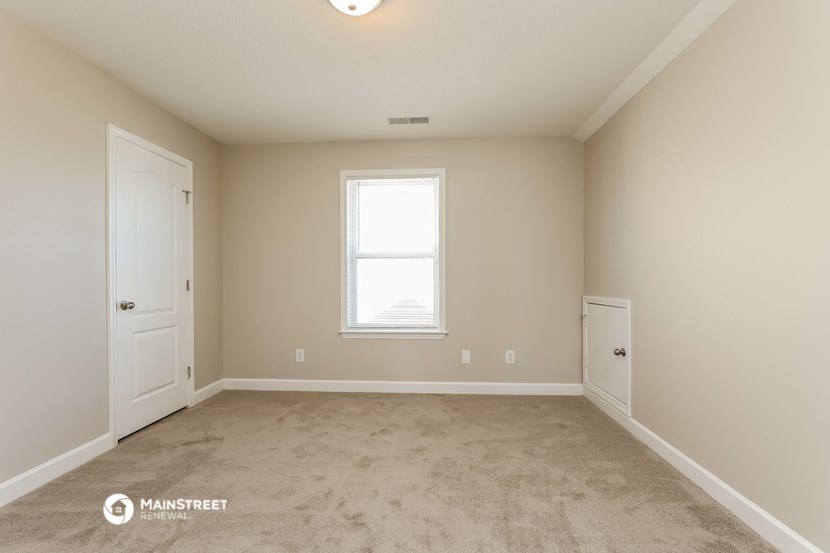 a bedroom with a carpeted floor and a window