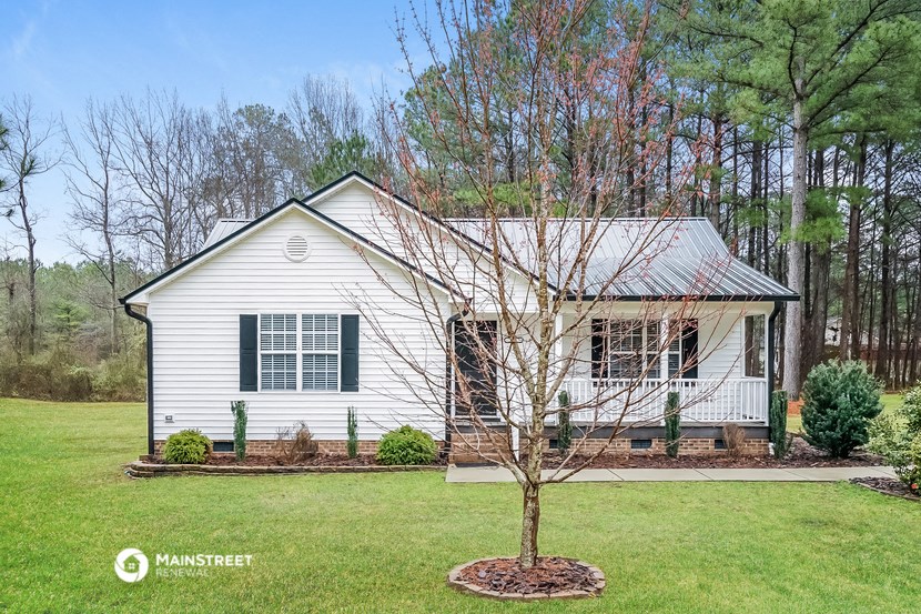 a white house with a tree in front of it