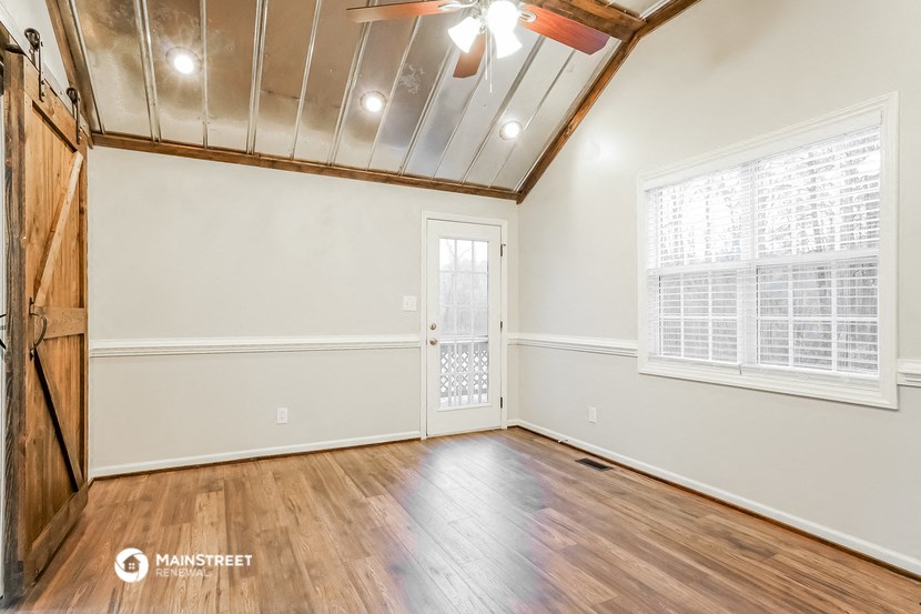 the living room of an empty house with wood floors and a door