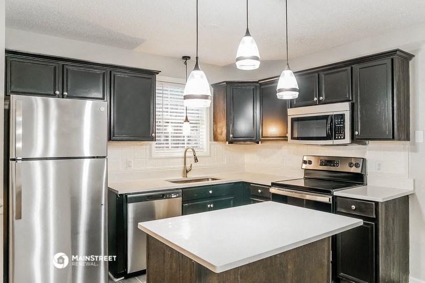 a kitchen with stainless steel appliances and black cabinets
