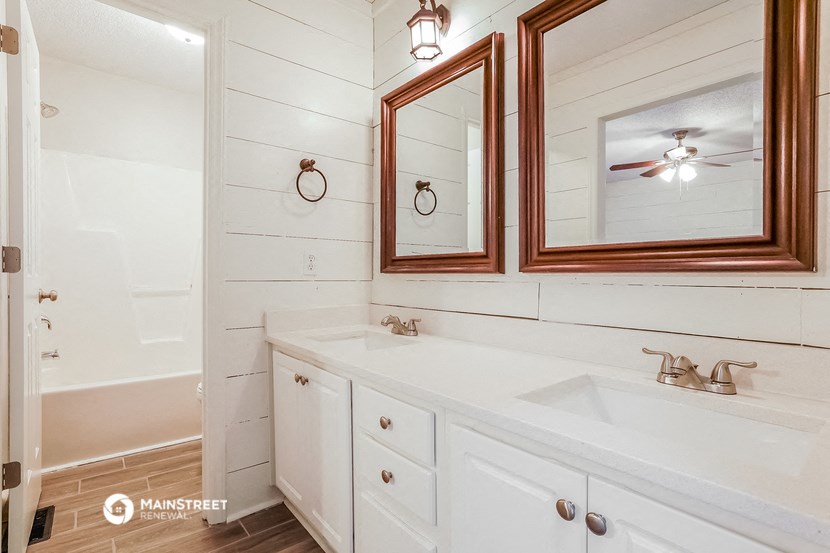 a bathroom with a sink and a mirror and a tub