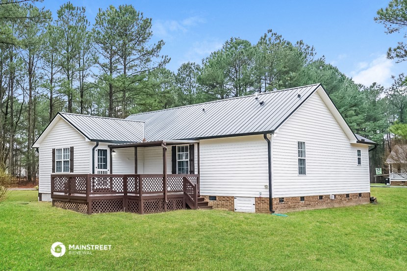 a white house with a porch and a metal roof