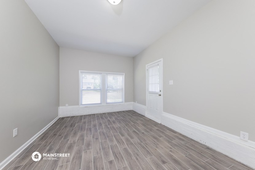 the living room of a new home with white walls and wood flooring
