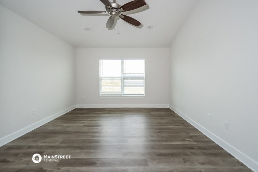 a living room with a ceiling fan and a window