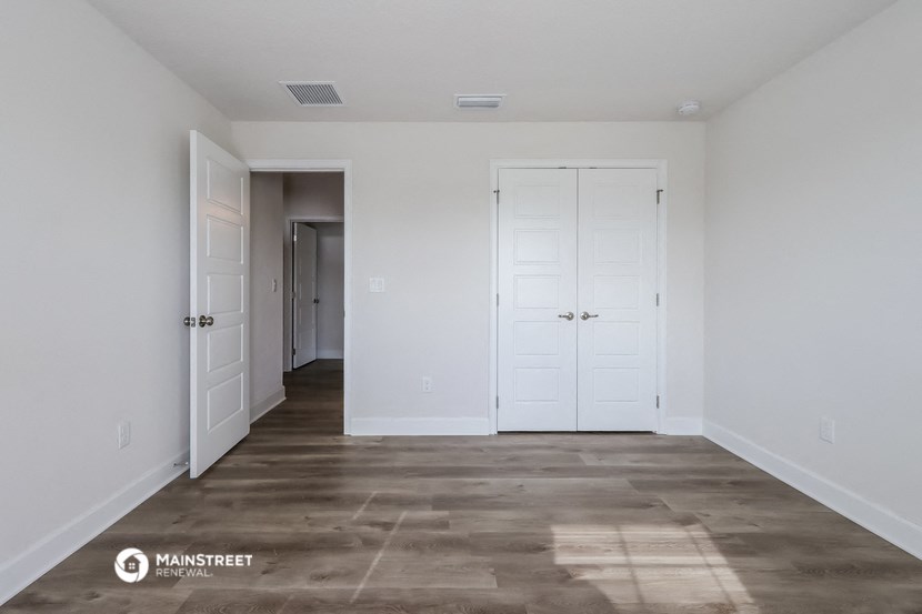 a renovated living room with white walls and white doors