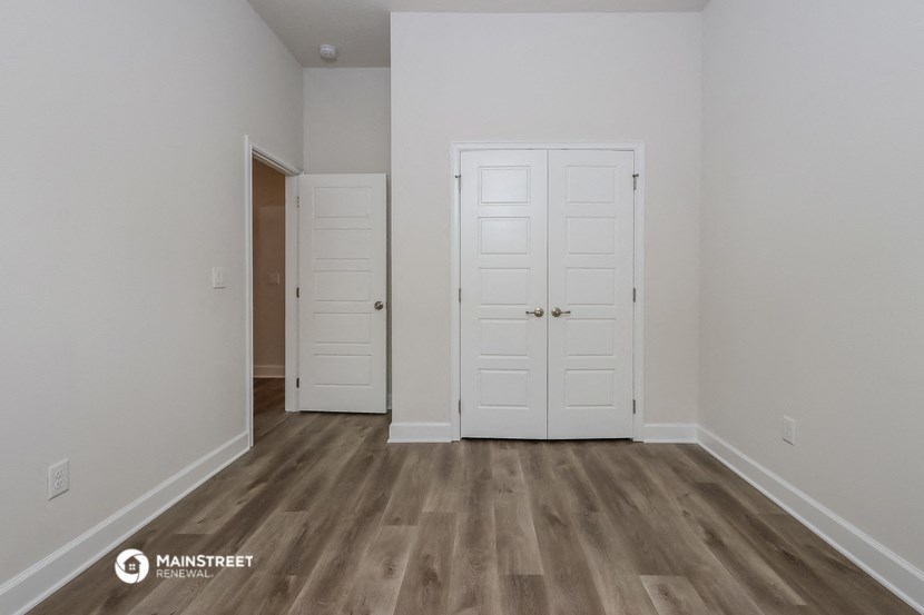 a bedroom with two doors and a door to a closet