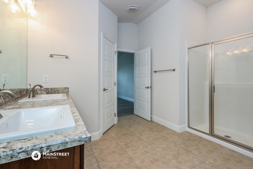 a white bathroom with a sink and a shower