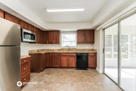 a kitchen with wooden cabinets and a sink and a refrigerator