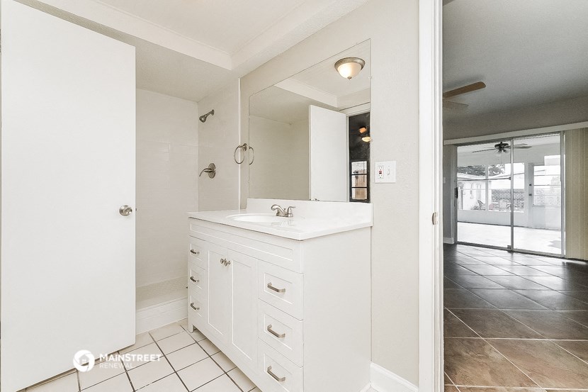 a white bathroom with a sink and a mirror