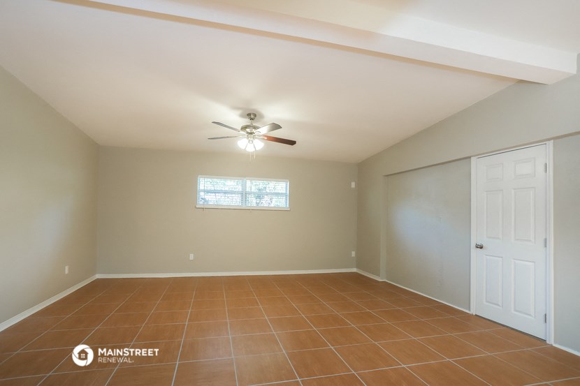 the living room of an empty house with a ceiling fan