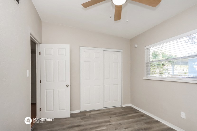 a bedroom with two closets and a ceiling fan