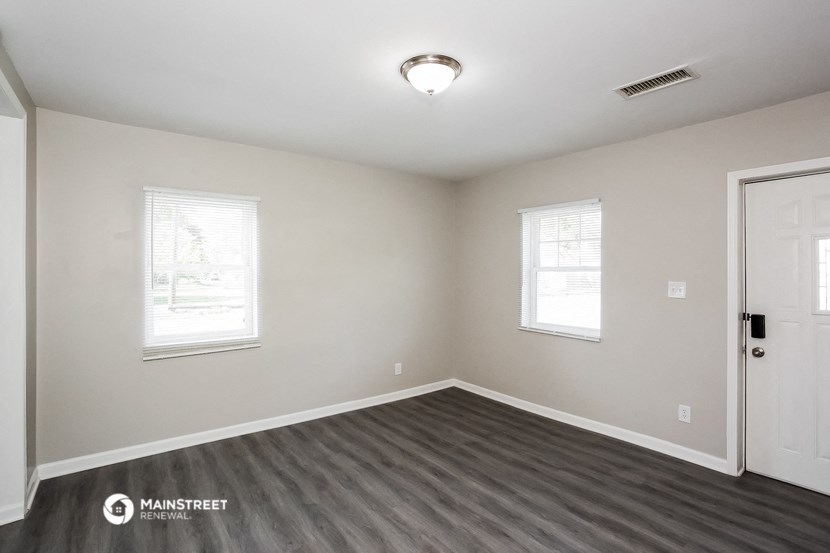 the interior of an empty room with wood flooring and white walls