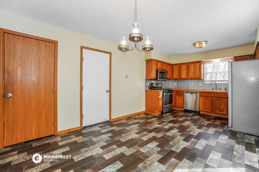 a kitchen with wood cabinets and stainless steel appliances and a checkered floor