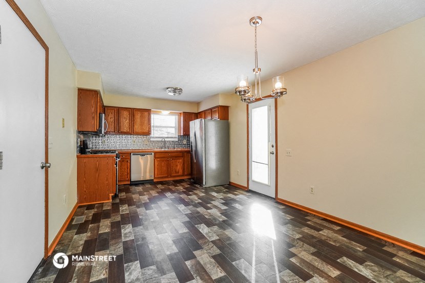 a kitchen with a stainless steel refrigerator and wooden cabinets