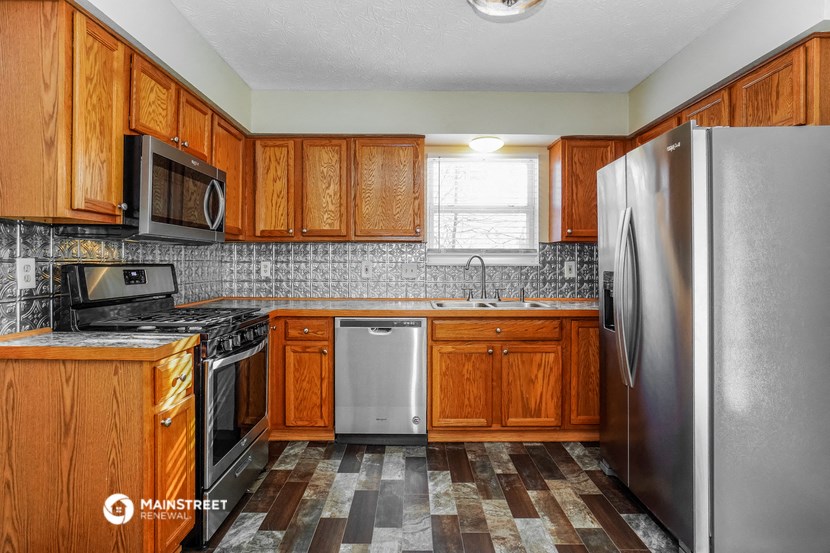 a kitchen with wooden cabinets and stainless steel appliances