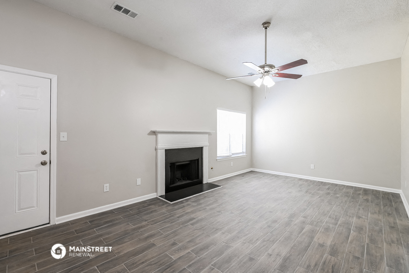 the living room with fireplace and ceiling fan