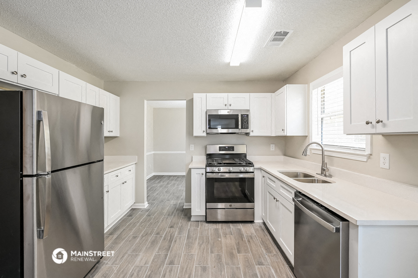 a kitchen with white cabinets and stainless steel appliances