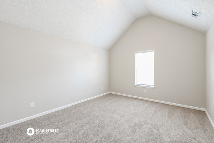 the upstairs bedroom with carpet and a window