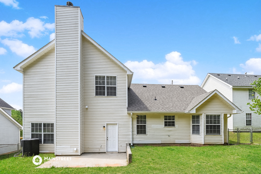 a white house with a gray roof and a yard