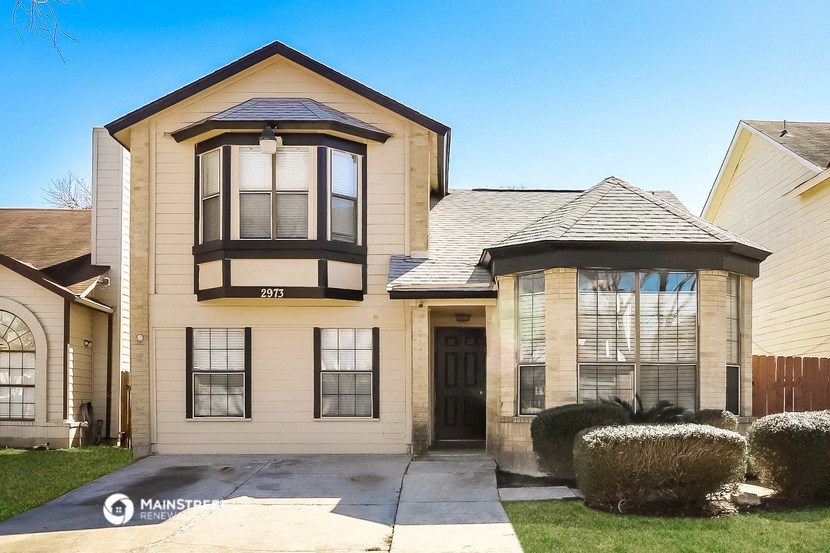 a tan house with black windows and a black door