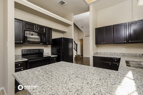 a kitchen with black appliances and granite counter tops