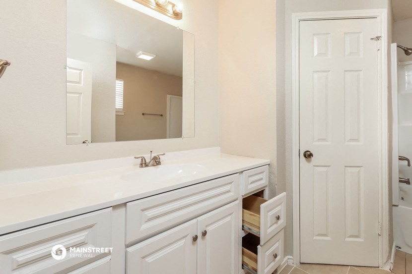 a white bathroom with a sink and a mirror