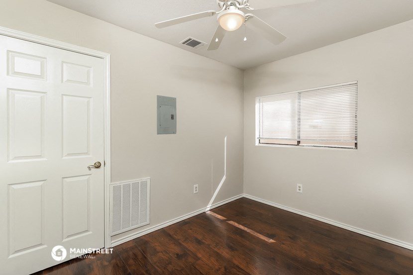 a bedroom with a white door and a ceiling fan