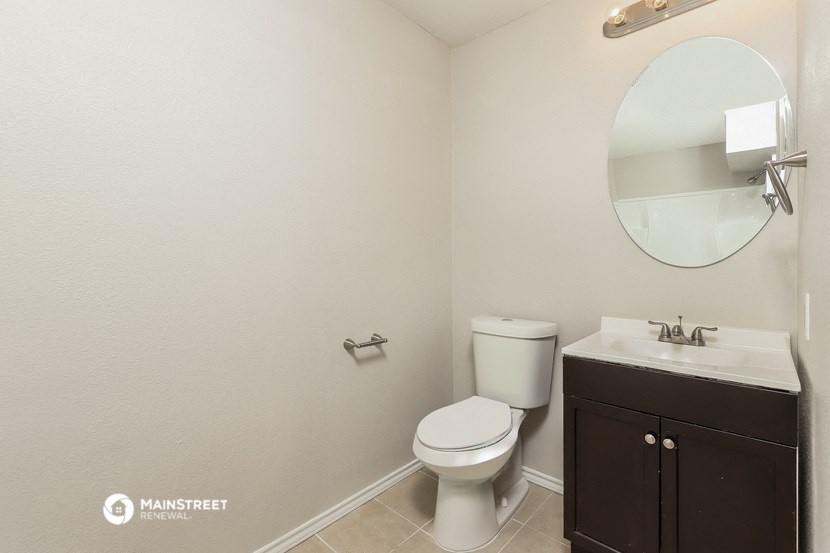 a bathroom with a toilet and a sink and a mirror