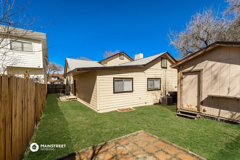 the backyard of a house with a yard and a fence