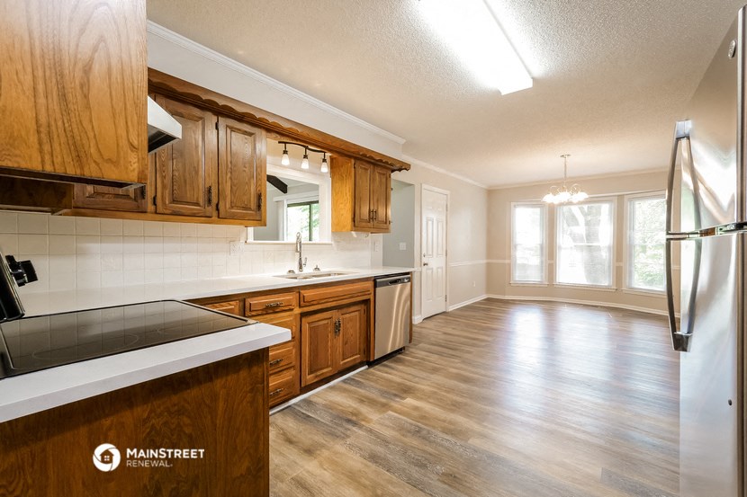 a kitchen with wooden cabinets and a sink and a refrigerator