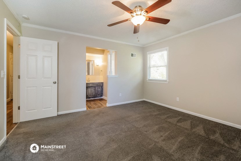 the living room of an empty house with a ceiling fan