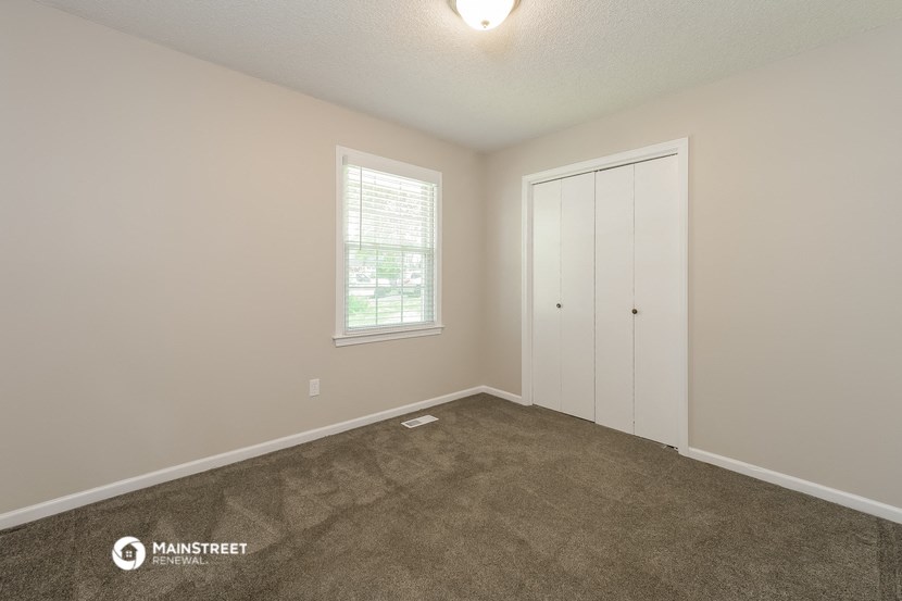 a room with carpet and a door and a window