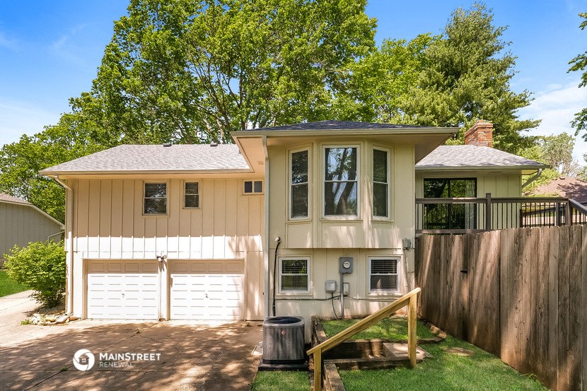 a house with a white garage door and a tree