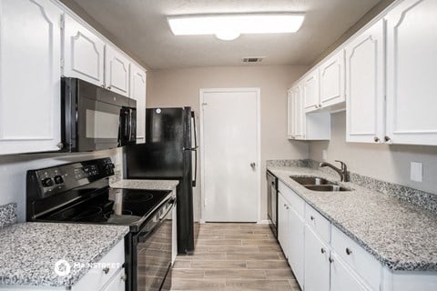 a kitchen with granite counter tops and black appliances