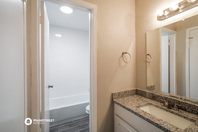 a bathroom with a sink and a shower and a mirror