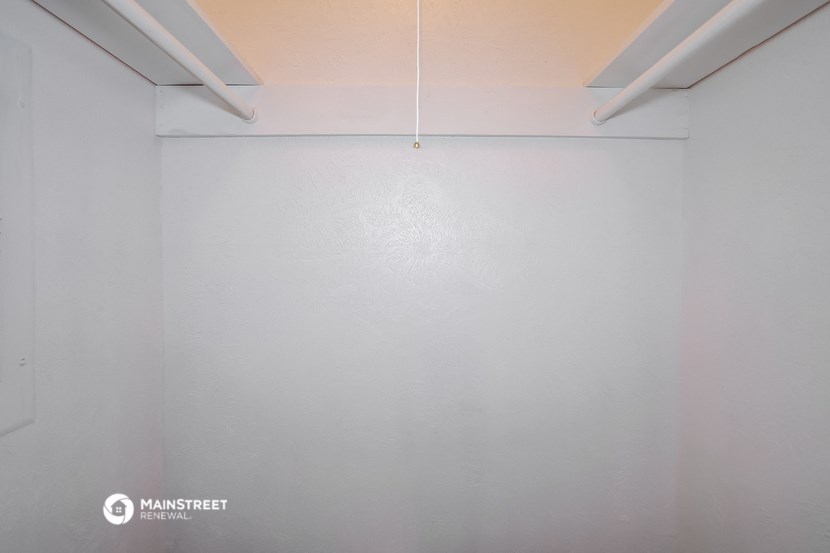 an empty room with white walls and a light hanging from the ceiling