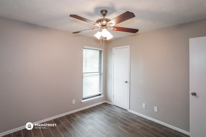 a living room with a ceiling fan and a window