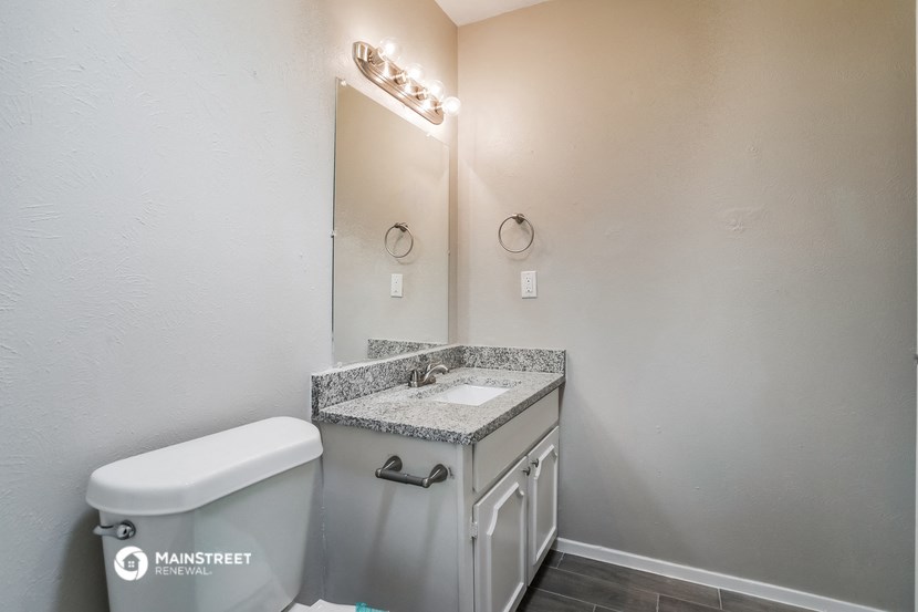 a bathroom with a toilet and a sink and a mirror