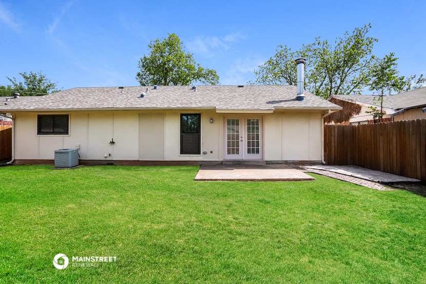 a white house with a grassy yard and a wood fence