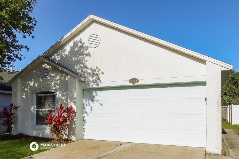 a white garage door in front of a white house