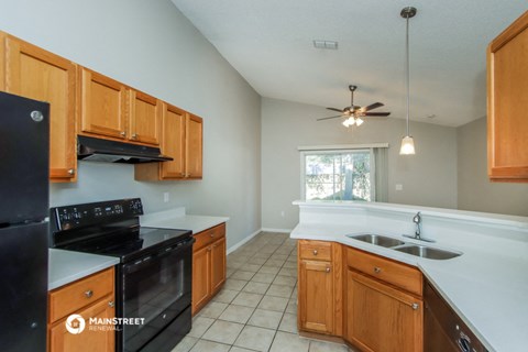 a kitchen with wooden cabinets and black appliances and a sink