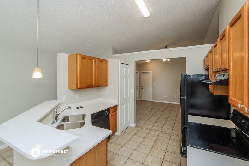 a kitchen with a sink and a black refrigerator