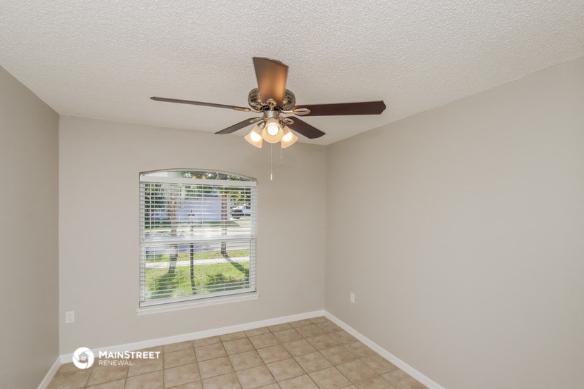 the living room has a ceiling fan and a window