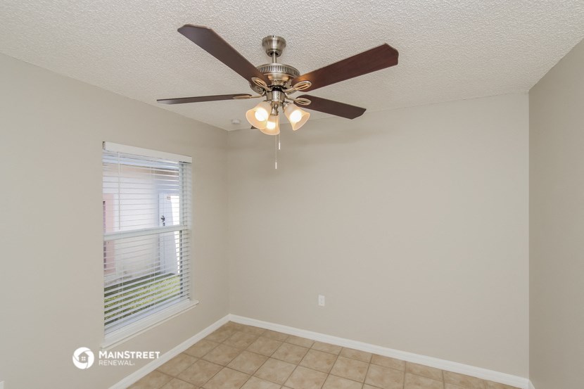 a bedroom with a ceiling fan and a window