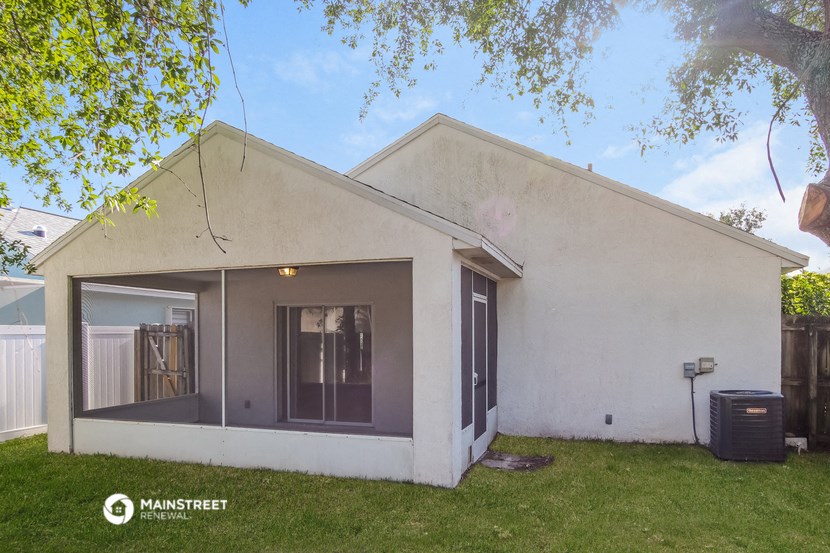 a white house with a yard and a tree