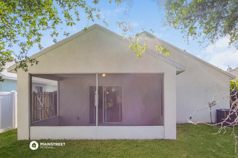 the exterior of a white house with glass doors and a lawn
