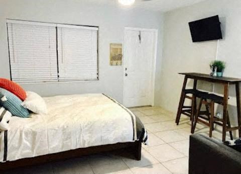 a bedroom with a bed and a table and a television