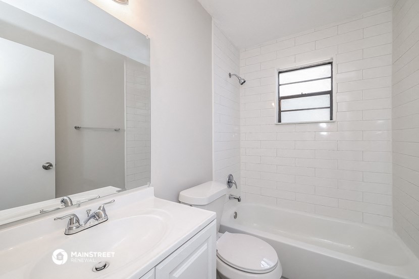 a bathroom with a sink toilet and tub and a mirror